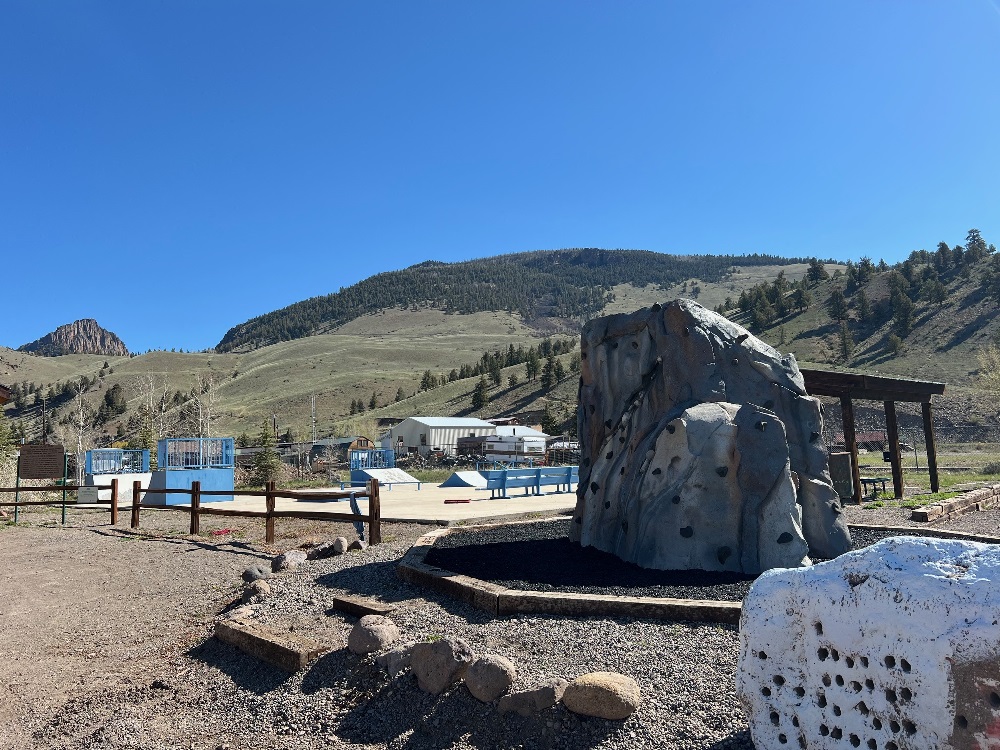 Photo of the Skate Park with ramps and rails, it even includes a climbing rock and small picnic pavilion.